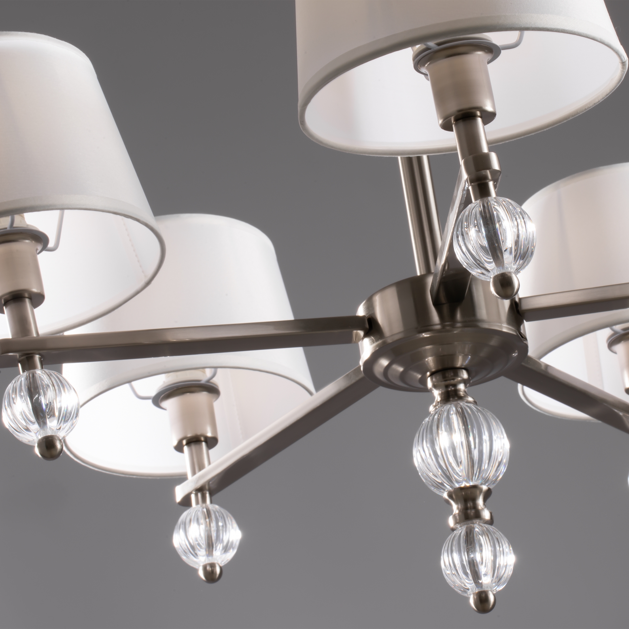 спален и офисов в современном стиле. Арматура из метала цвета “никель” дополнена декоративными элементами из прозрачного акрила (шарики). Белые абажуры из текстиля на ПВХ. Люстра Freya FR5679PL-05N